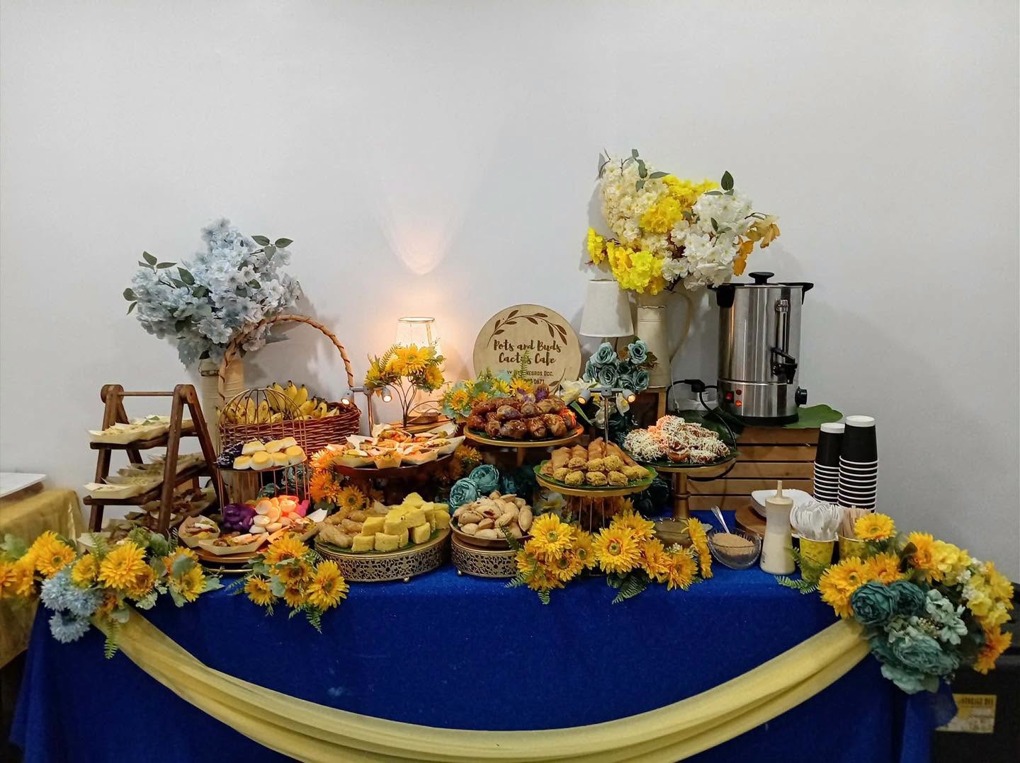 A styled catering spread with pastries, savory bites, fruit, and drinks from Pots and Buds Cactus Cafe