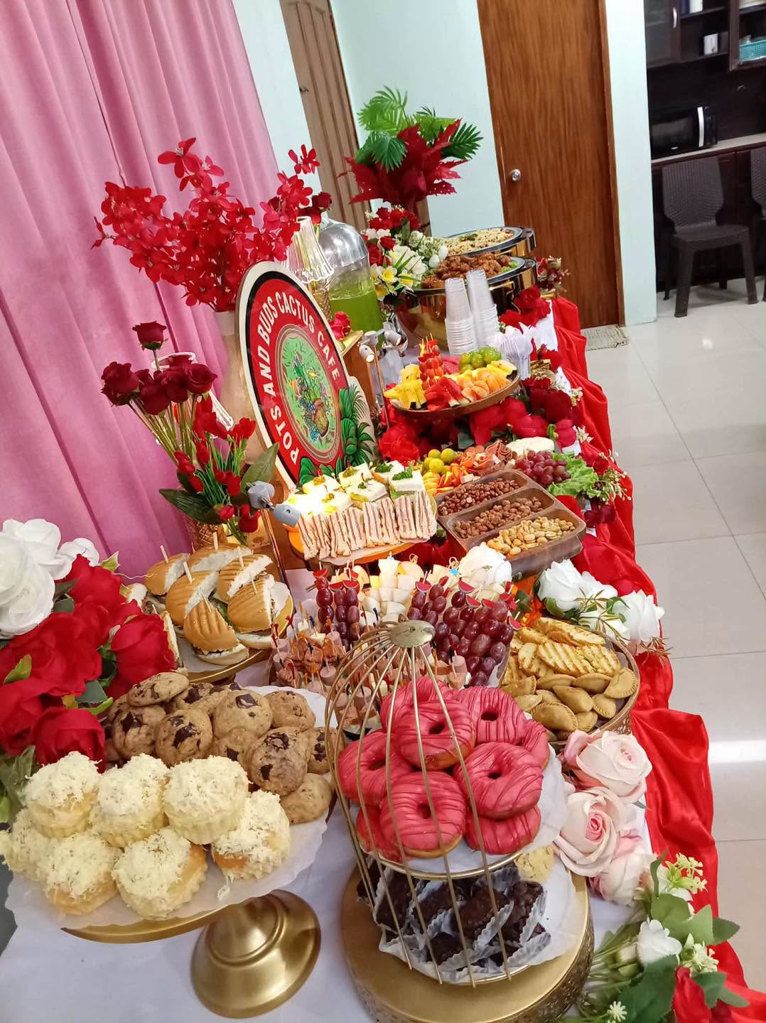 A colorful catering and grazing table with sandwiches, fruit, desserts, and savory bites from Pots and Buds Cactus Cafe